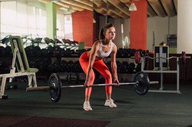 Genç kadının bacakları spor salonunda egzersiz deadlift yapması yerleştirmek