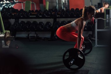 Genç kadının bacakları spor salonunda egzersiz deadlift yapması yerleştirmek