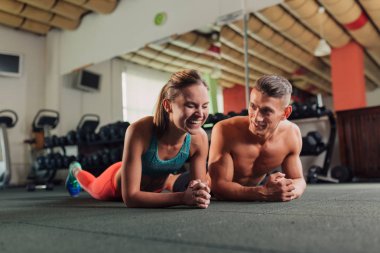 Genç mutlu çift planking yapmaya spor salonunda egzersiz yerleştirmek