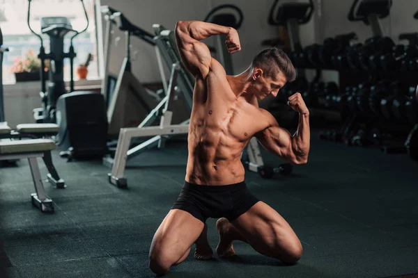 Giovane uomo in forma facendo bodybuilding concorrenza pose — Foto Stock