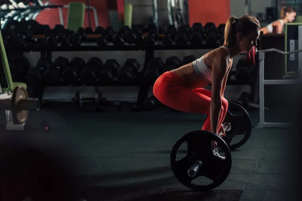 Genç kadının bacakları spor salonunda egzersiz deadlift yapması yerleştirmek