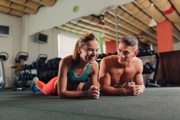Genç mutlu çift planking yapmaya spor salonunda egzersiz yerleştirmek