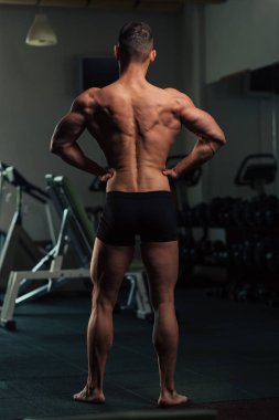 Vücut geliştirme yarışması pozlar yapan erkek genç yerleştirmek