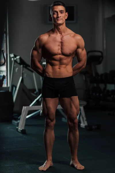 Young fit man doing bodybuilding competition poses — Stock Photo, Image