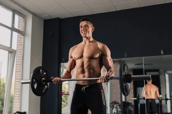 Giovane uomo muscoloso in palestra facendo esercizio — Foto Stock