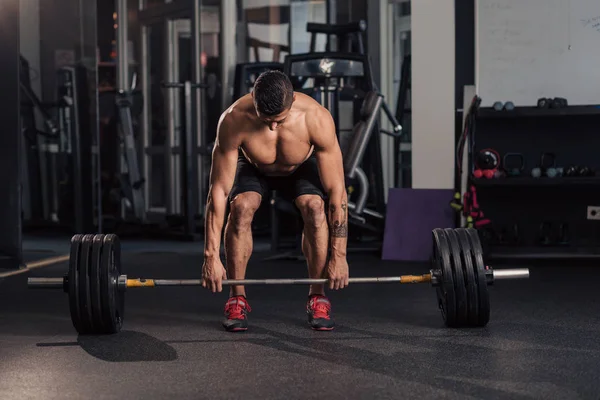 Giovane uomo muscoloso in palestra facendo esercizio — Foto Stock