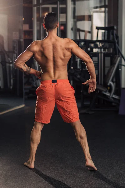 Young muscular man in the gym doing exercise — Stock Photo, Image