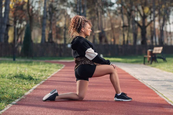 Young attractive woman enjoying outdoor physical exercise in the city