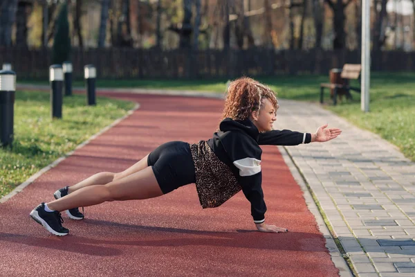 Jonge aantrekkelijke vrouw genieten van outdoor fysieke oefening in de stad — Stockfoto