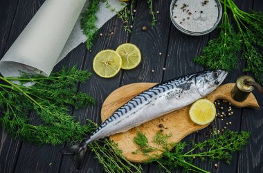 Yemek malzemelerle taze uskumru: limon, yeşil ve baharat. Otlar ile balık pişirme