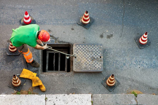 Reihenfolge Der Arbeiter Die Den Schacht Auf Der Straße Gehen Stockfoto