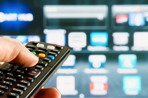 remote control interacting with smart television hold in hand