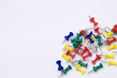 Renkli raptiyelerden oluşan bir kollektif beyaz bir yüzeye dağılmış, canlı ve düzenli bir desen yaratıyor..