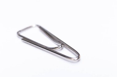 Temiz beyaz bir zemin üzerinde duran tek bir gümüş kağıt atacının yakın plan çekimi, metalik dokusu ve basit tasarımı sergiliyor..