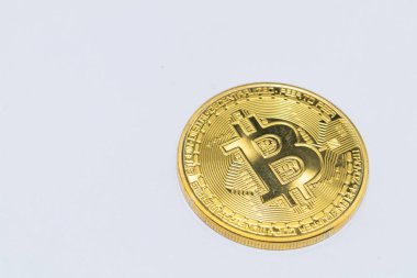 Sade beyaz arka planda tek bir altın Bitcoin sikkeye yakın plan. Kripto para birimi, dijital finans ve yatırım olanakları sunar.