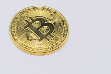 Tek bir altın Bitcoin 'in yakın plan çekimi, onun karmaşık tasarımı ve ayrıntıları sergileniyor, temiz beyaz bir arka planda izole edilmiş..