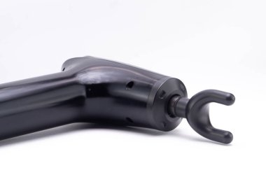 Temiz beyaz bir arka planda izole edilmiş, kancaya takılı siyah plastik bir elin yakın plan çekimi..