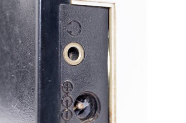 Çeşitli portların ve sembollerin yer aldığı siyah elektronik bir cihazın ayrıntılı görüntüsü, temiz beyaz bir arkaplan üzerine kurulmuş.