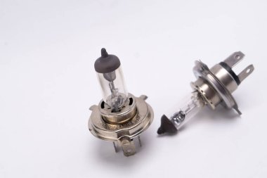 Beyaz zemin üzerinde iki halojen far ampulü sergileniyor, otomotiv aydınlatma bileşenleri ve tasarım sergileniyor.