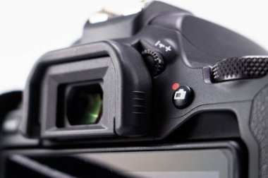 Siyah bir DSLR kameranın ayrıntılı yakın plan görüntüleyicisi, tuşları ve temiz beyaz zemin üzerindeki düğmelere odaklanmış.