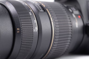 Odak halkaları ve desenli tutuşu gösteren siyah bir kamera merceğinin ayrıntılı görüntüsü. Görüntü, mercek tasarımı ve profesyonel kaliteyi vurgular.