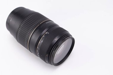 Siyah bir kamera merceği beyaz bir arkaplanda görüntülenir, tasarımı ve özellikleri yakın plan çekimde sergilenir.