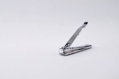 Temiz beyaz arka planda gümüş bir tırnak makasının yakın plan çekimi, tasarımın ve kişisel bakım amacının altını çiziyor..