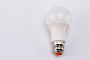 Temiz beyaz arkaplanda beyaz bir LED ampulün yakın çekimi. Ampul modern ve enerji tasarruflu, tasarımı ve inşaatı sergileniyor..