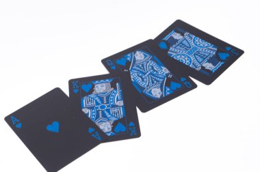 Mavi kral ve kraliçe takımlarının yer aldığı dört siyah oyun kartı beyaz bir arkaplanda sergilenmektedir. Kartlar çapraz olarak düzenlenmiştir..