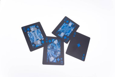 Koyu kenarlı ve mavi renkli dört iskambil kartı beyaz bir zemine dağılmış, rastgele ve soyut bir düzenleme yaratıyor..