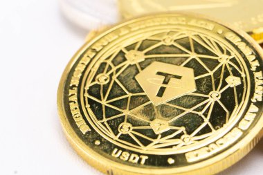 Altın renkli USDT paranın detaylı makro görüntüsü, beyaz arka planda ağ desenini ve tasarımını gösteriyor.