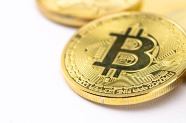 Yakın plan çekimde, temiz beyaz arka planda siyah B logosu olan bir Bitcoin şifreli altın sikke kullanılıyor. Dijital para birimi kavramı.