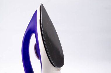 Modern bir demire yakın çekim, mavi saplı, beyaz gövdeli ve parlak siyah tabanlı, temiz beyaz arkaplanlı.