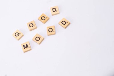 Ahşap harfli karoların olduğu minimalist bir resim. Temiz beyaz arkaplana saçılmış iyi MOOD yazılıyor. Basit ve olumlu bir mesaj yaratıyor..