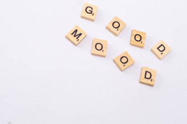 Ahşap harf kiremitleri İyi Ruh hali temiz, beyaz bir yüzey üzerinde düzenlenir, Olumlu ve neşeli bir mesaj iletir.