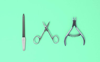 Yalıtılmış tırnak makası, tırnak makası ve tırnak törpüsü seti yeşil arka planda 