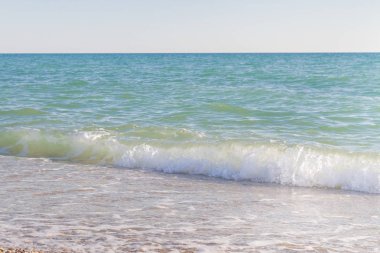 Sandy ve çakıl plaj üzerinde çalışan deniz dalgası