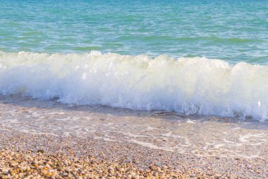 Sandy ve çakıl plaj üzerinde çalışan deniz dalgası