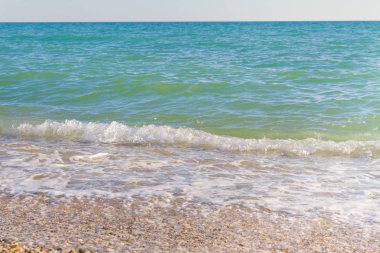 Sandy ve çakıl plaj üzerinde çalışan deniz dalgası