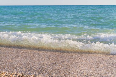 Sandy ve çakıl plaj üzerinde çalışan deniz dalgası