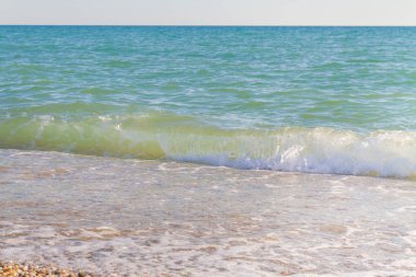 Sandy ve çakıl plaj üzerinde çalışan deniz dalgası