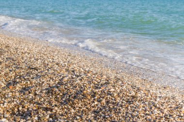 Sandy ve çakıl plaj üzerinde çalışan deniz dalgası