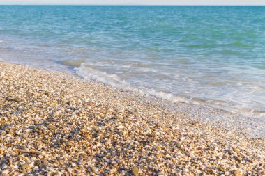 Sandy ve çakıl plaj üzerinde çalışan deniz dalgası