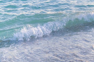 Sandy ve çakıl plaj üzerinde çalışan deniz dalgası