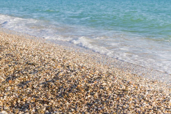 Sandy ve çakıl plaj üzerinde çalışan deniz dalgası