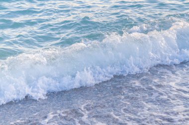 Sandy ve çakıl plaj üzerinde çalışan deniz dalgası