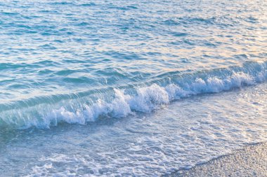 Sandy ve çakıl plaj üzerinde çalışan deniz dalgası