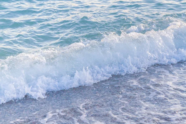 Sandy ve çakıl plaj üzerinde çalışan deniz dalgası