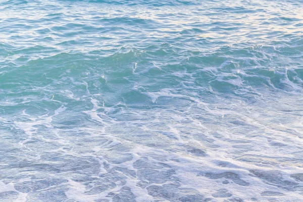 Sandy ve çakıl plaj üzerinde çalışan deniz dalgası