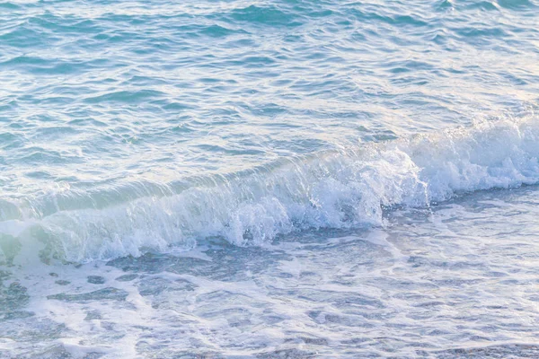 Sandy ve çakıl plaj üzerinde çalışan deniz dalgası